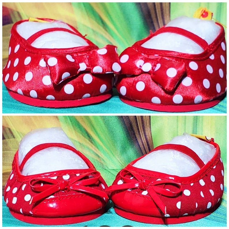 K&ouml;nnte beinhalten: Ein Paar rote Babyschuhe mit wei&szlig;en Tupfen. Jeder Schuh hat eine rote Schleife und einen Riemen &uuml;ber dem Oberteil. Die Sohlen sind rot und die Schuhe sind mit wei&szlig;em Papier gef&uuml;llt.