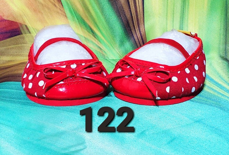 K&ouml;nnte beinhalten: Paar rote Ballerinas mit wei&szlig;en Punkten und Schleife. Die Schuhe haben einen Riemen &uuml;ber dem Oberteil und ein gl&auml;nzendes Finish. Die Nummer "122" ist im Bild zu sehen.