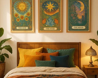 May include: Three framed tarot card prints: "The Sun," "The Star," and "The Moon." Each features intricate illustrations in a vintage style, with warm colors and detailed borders. The prints are displayed above a bed with colorful pillows and a patterned throw.