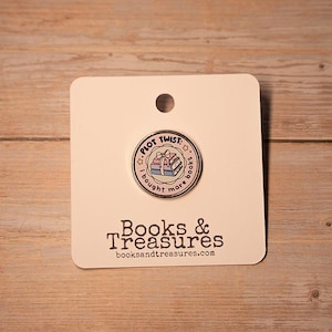 May include: A round enamel pin with the text "PLOT TWIST: I bought more books" around a stack of books with a gift. The pin is on a white card with the text "Books & Treasures" and the website address.