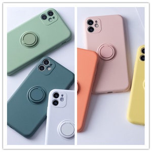 May include: Five silicone phone cases in different colors with a built-in ring holder. The cases are green, blue, white, orange, and yellow.