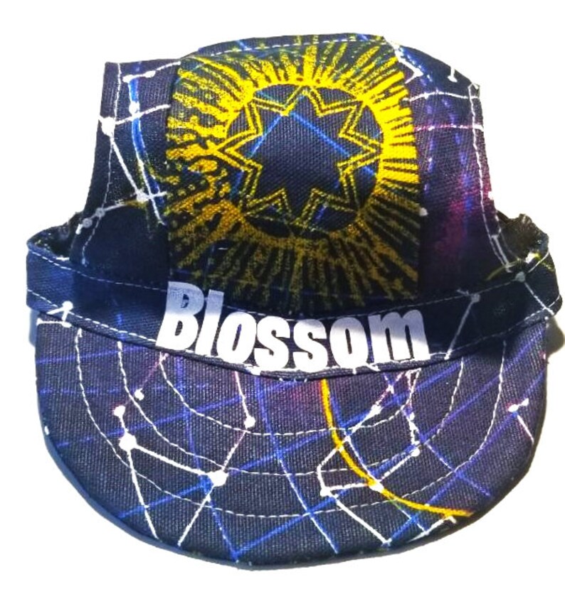 May include: A black, blue, and yellow cycling cap with a starburst design and the word "Blossom" printed on the front.