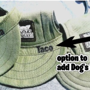 May include: Three green canvas dog hats with adjustable straps. The hats have a patch with the word "cachorro" on them. The hats are personalized with the names "Chica", "Taco", and "Belle".