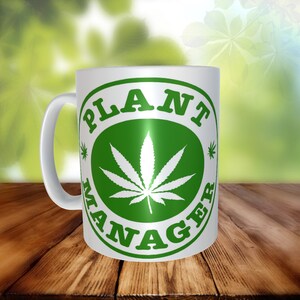 May include: White ceramic mug with a green circle design. The circle has the words "PLANT MANAGER" written around the outside and a white marijuana leaf in the center.