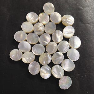 Puede incluir: Colección de cuentas redondas e iridiscentes de concha de nácar. Las cuentas son de color blanco cremoso con una superficie sutil y brillante. Ideales para la creación de joyas y proyectos de artesanía.