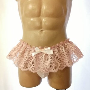 Pu&ograve; includere: Un lingerie in pizzo rosa con un fiocco bianco. Il pizzo &egrave; delicato e presenta un motivo floreale. Il lingerie &egrave; su un manichino.