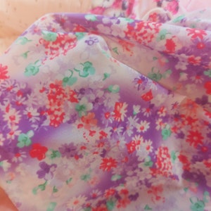 Puede incluir: Primer plano de una tela p&uacute;rpura y blanca con un patr&oacute;n floral. La tela es transparente y tiene un tacto suave y delicado.