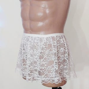 Puede incluir: Falda de encaje blanca con cintura el&aacute;stica blanca. La falda es transparente y tiene un delicado estampado floral.