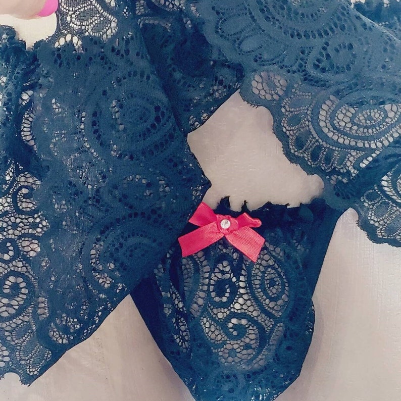May include: Black lace lingerie with a red bow detail.