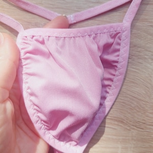 Puede incluir: Lencería rosa con un delicado borde de encaje. La tela es suave y sedosa.