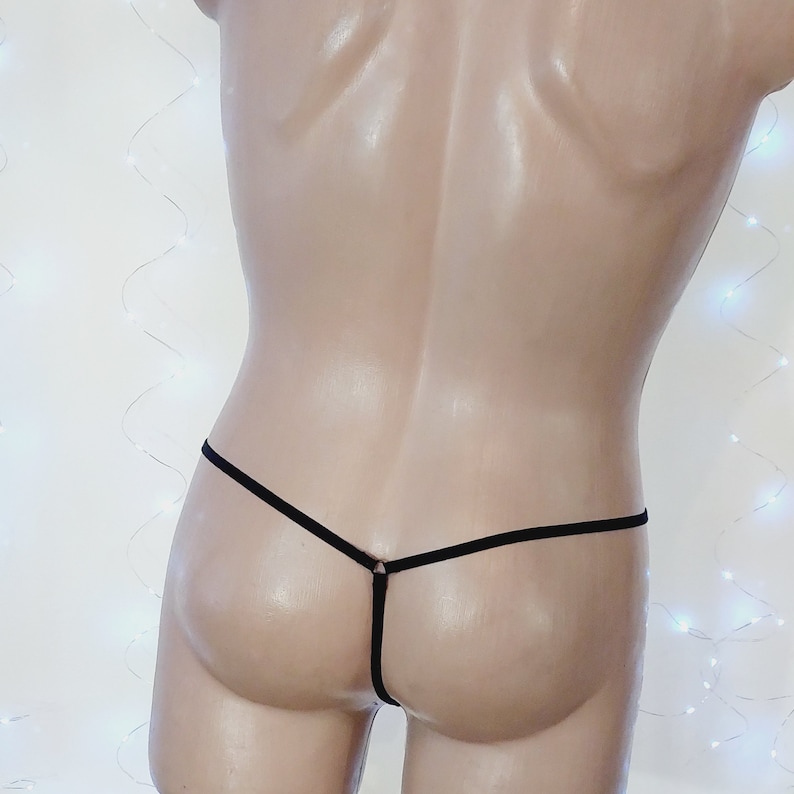 Puede incluir: Ropa interior de hilo negro con una sola tira fina en la espalda.