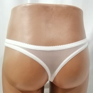 Puede incluir: Tanga de encaje blanco con detalles de encaje blanco.