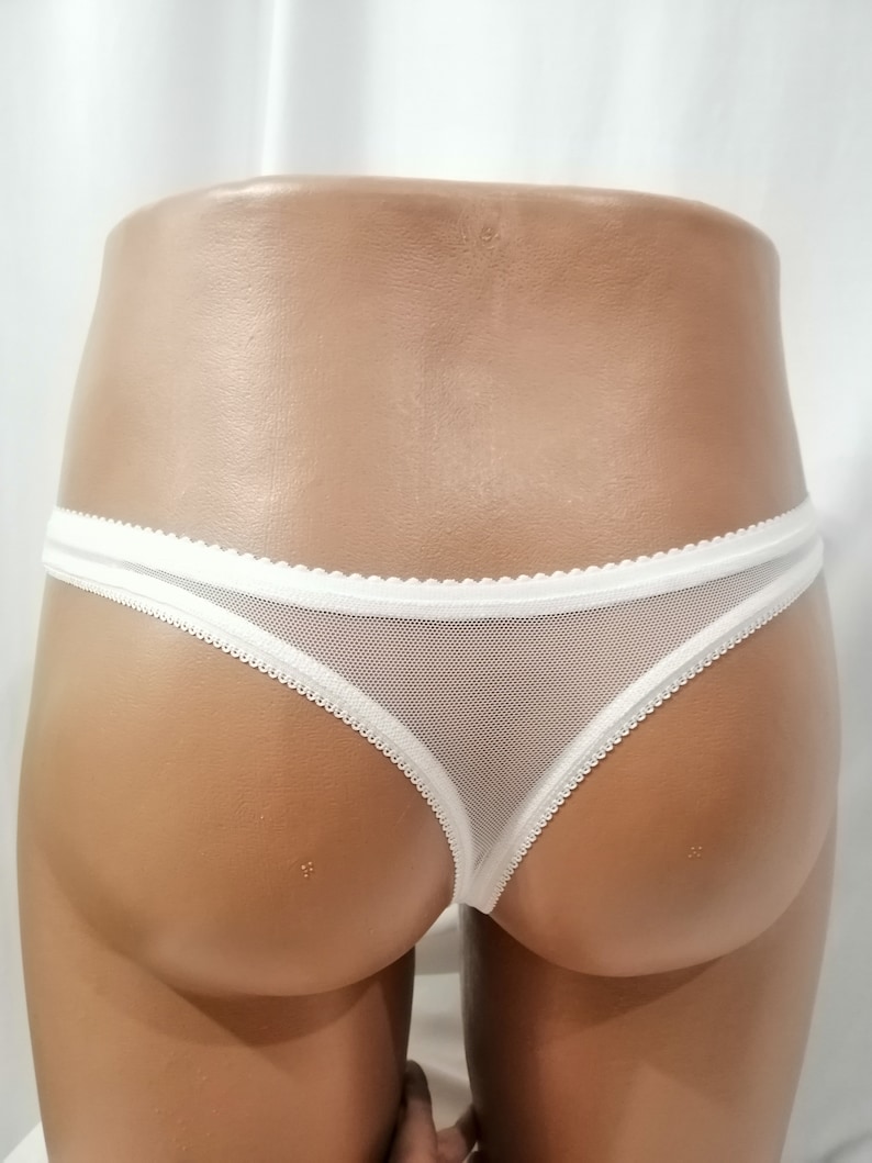 Puede incluir: Tanga de encaje blanco con detalles de encaje blanco.