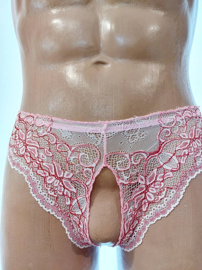 May include: Pink and white lace underwear with a floral design. The underwear has a keyhole opening in the front. The edges are scalloped.
