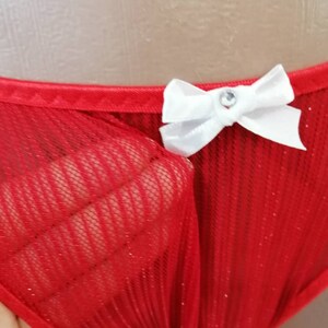 May include: Red mesh underwear with a white bow and a rhinestone in the center.