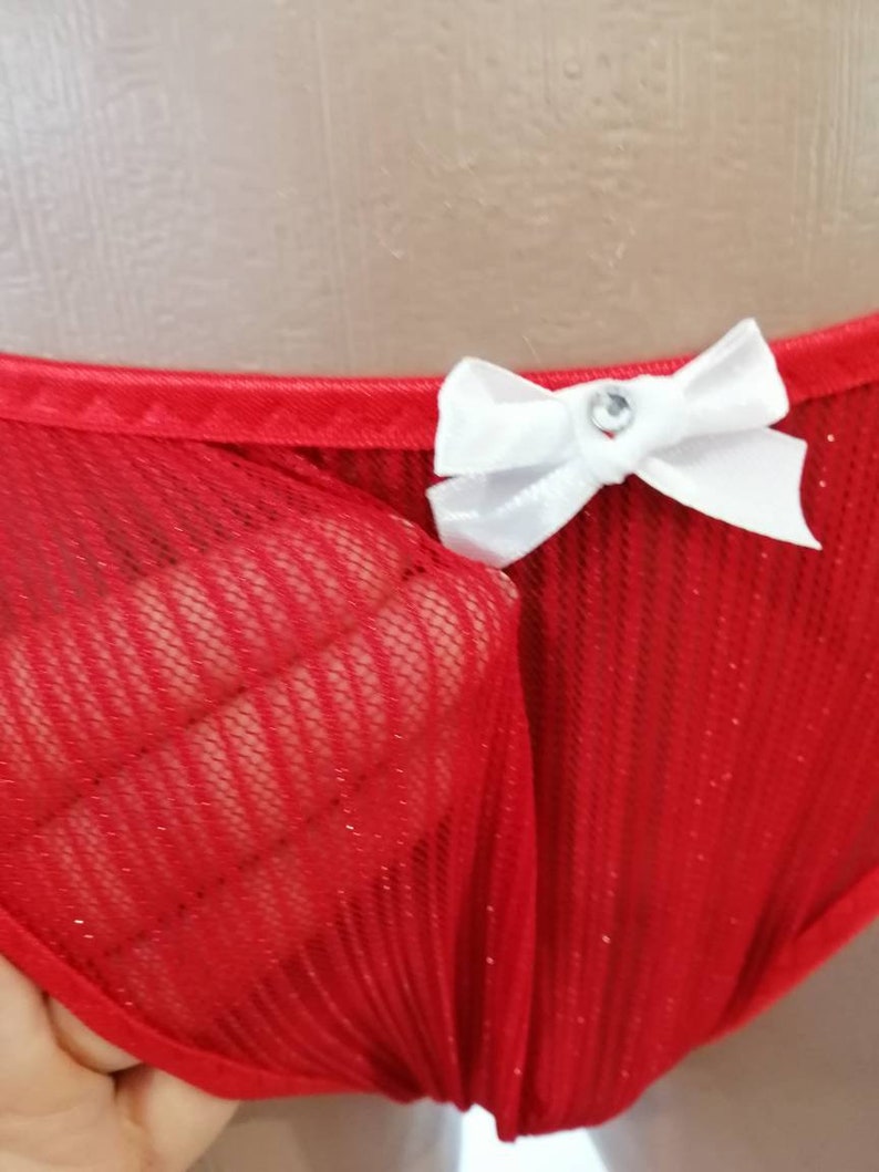 May include: Red mesh underwear with a white bow and a rhinestone in the center.