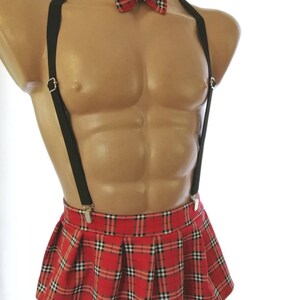 Puede incluir: Una minifalda de cuadros rojos y negros con tirantes negros y una pajarita roja y negra.