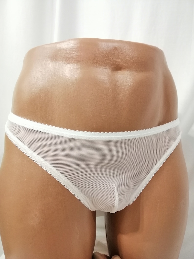 Puede incluir: Ropa interior de malla blanca con ribete blanco. La ropa interior est&aacute; en un maniqu&iacute; de color carne.