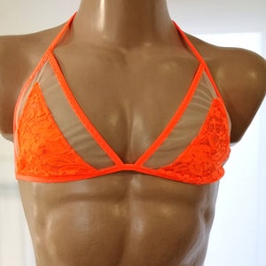 May include: A bright orange lace and mesh bra with adjustable straps. The bra has a triangle shape and is made of a sheer fabric.