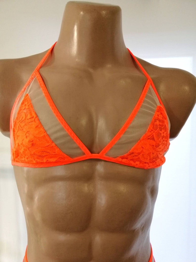 May include: A bright orange lace and mesh bra with adjustable straps. The bra has a triangle shape and is made of a sheer fabric.