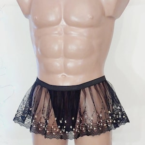 May include: Black sheer mini skirt with delicate floral embroidery and lace trim. The skirt features a black elastic waistband and a layered design, creating a flowing, lightweight appearance. The skirt is designed for a comfortable fit.
