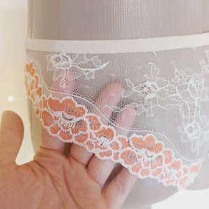 Puede incluir: Ropa interior de encaje blanco con un patr&oacute;n floral de color melocot&oacute;n.