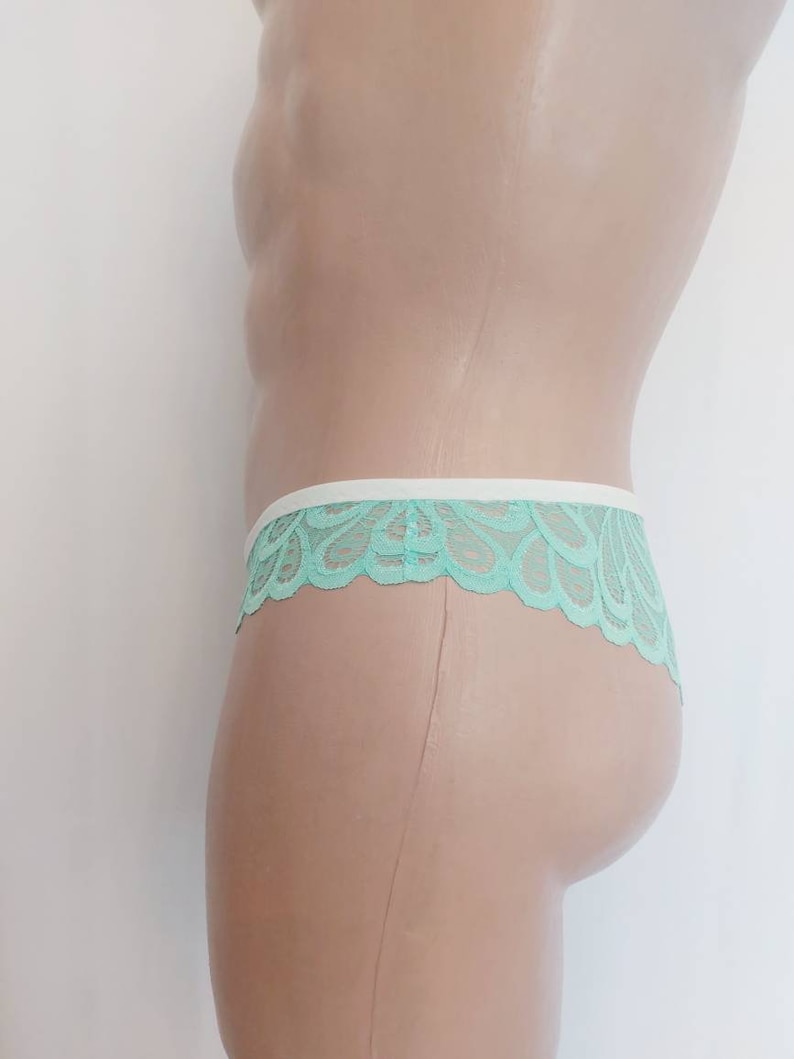 May include: Mint green lace underwear with a white trim. The underwear is shown on a mannequin.