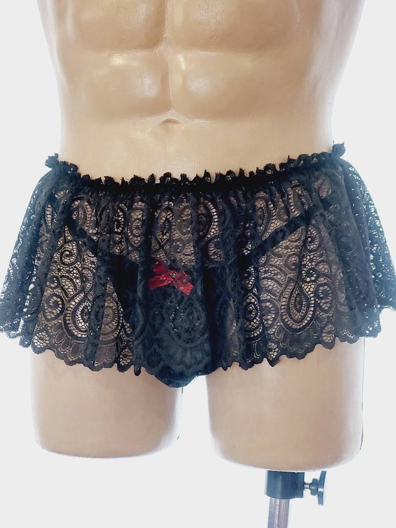 May include: Black lace lingerie with a ruffled trim and a red bow detail.