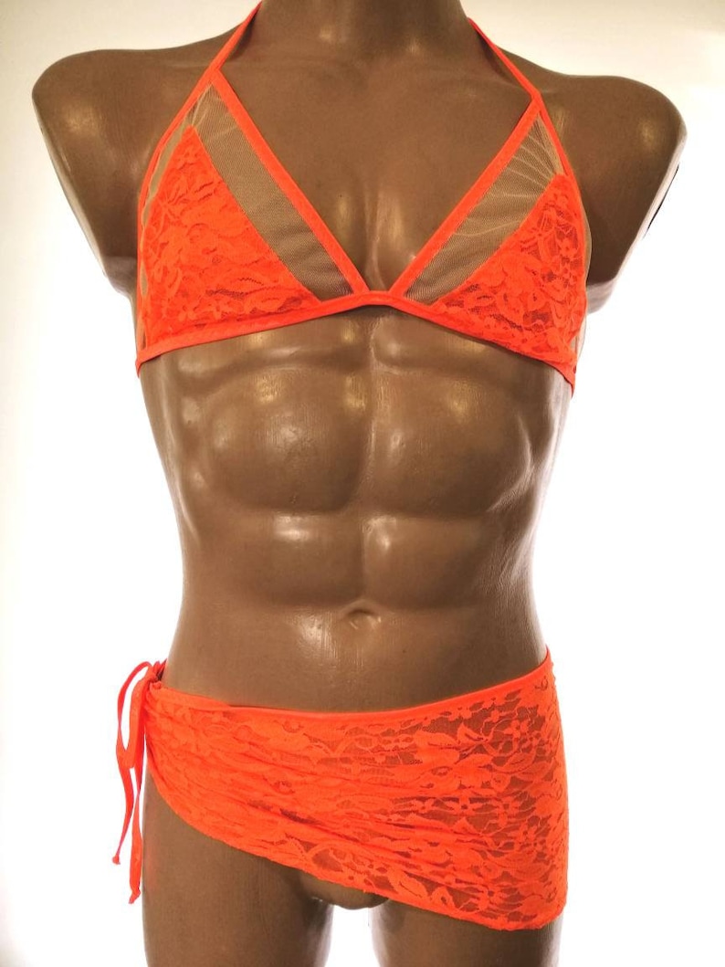 May include: A bright orange lace bra and matching skirt set. The bra has a halter style with a mesh panel in the center. The skirt is a wrap style with a tie at the side.