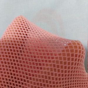 Puede incluir: Tela de malla rosa con un patr&oacute;n de diamante. La tela es suave y flexible.