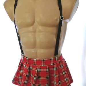 Puede incluir: Una minifalda de cuadros rojos y negros con tirantes negros y una pajarita roja y negra.