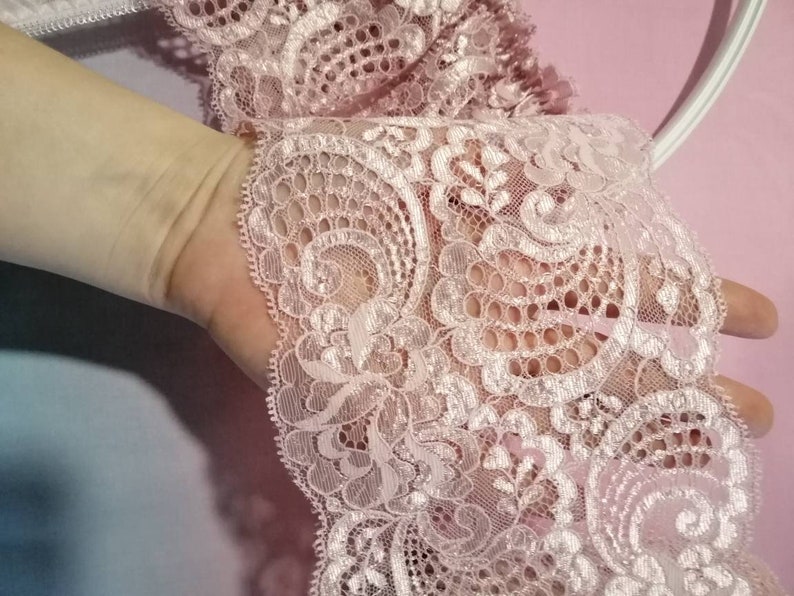 Pu&ograve; includere: Bordino in pizzo rosa con un delicato motivo floreale. Il pizzo ha una finitura leggermente scintillante.