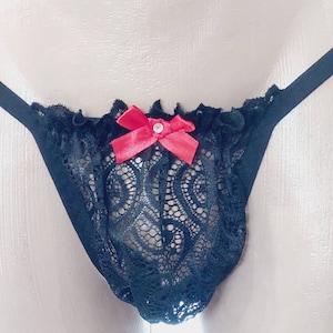 May include: Black lace underwear with a red bow and a rhinestone in the center.