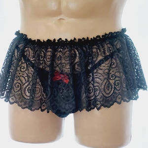 May include: Black lace lingerie with a red bow detail. The lingerie has a ruffled trim and a sheer design.
