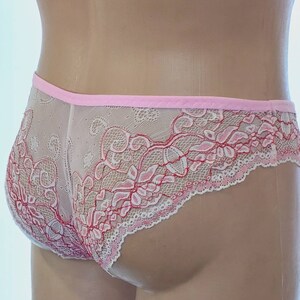 May include: Pink and white lace underwear with a delicate floral pattern. The underwear has a pink elastic waistband.