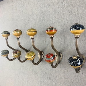 Puede incluir: Un juego de tres tazas de cerámica con un acabado mate moteado. Las tazas son en tonos crema, gris claro y gris oscuro. Cada taza tiene un diseño simple y minimalista, ideal para café o té.