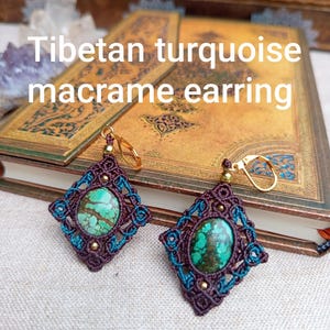 May include: A pair of Tibetan turquoise macrame earrings featuring oval-shaped turquoise stones with brown matrix, encased in dark brown and teal knotted cord in a diamond pattern, accented with small gold-tone beads and gold-tone lever-back hooks.