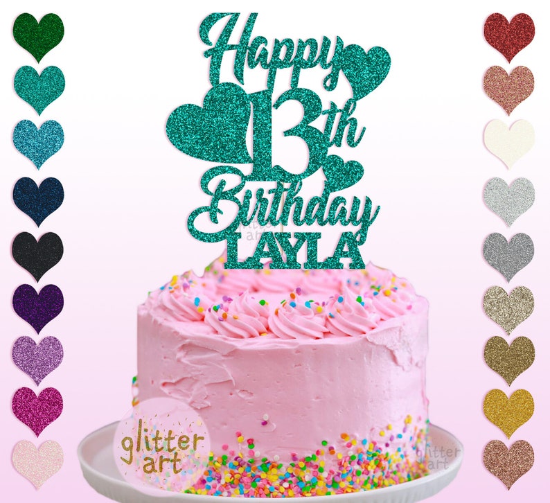 Pu&ograve; includere: Un topper per torta di glitter turchese con il testo "Happy 13th Birthday LAYLA". Il topper &egrave; su una torta rosa con codette colorate.