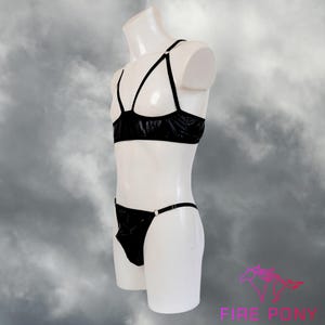 May include: Black lingerie set with a bra and a thong. The bra has a criss-cross strap design and the thong has a thin strap.