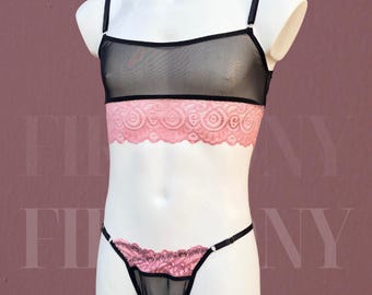 May include: Black mesh lingerie set with pink lace accents. The set includes a bralette with adjustable straps and a matching thong. The bralette features a pink lace band, and the thong has a pink lace trim.