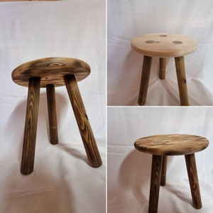 May include: Three wooden stools with a round top and three legs. The stools are made of natural wood with a dark brown finish.