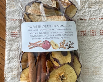 Popurrí a fuego lento en la estufa para el clima de suéter con una mezcla de rodajas de manzana seca, pera, jengibre molido, clavo y ramas de canela, regalos navideños
