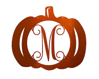 May include: A metal pumpkin cutout with a monogrammed letter "M" in the center. The pumpkin is a rusty orange color.