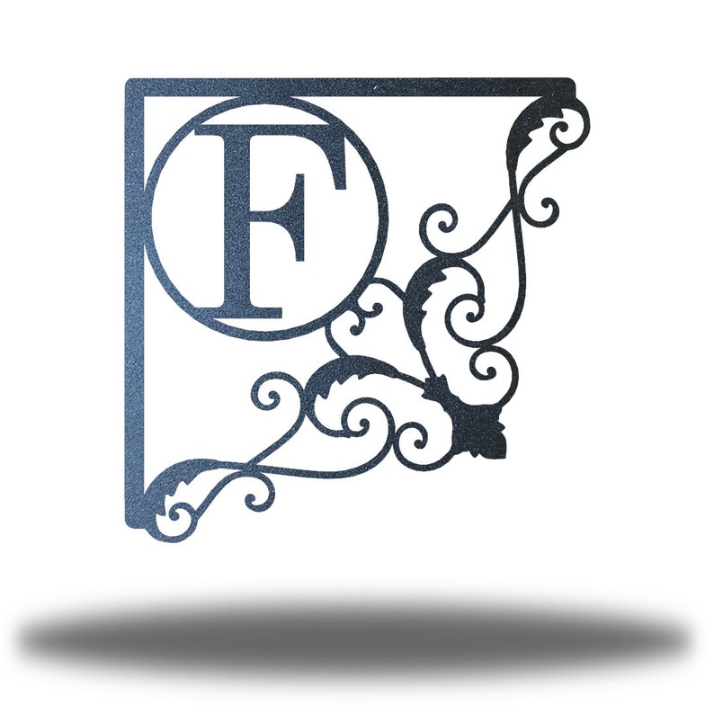 May include: A metal monogram sign featuring the letter "F" within a circle, enclosed by a square frame and an ornate scroll design.