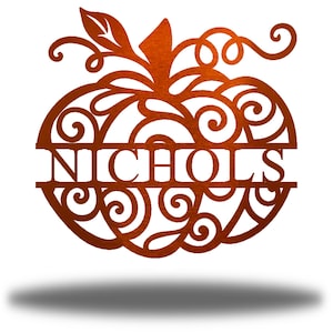 May include: A metal pumpkin with a decorative swirl design and the name "NICHOLS" in the center. The pumpkin is a rusty orange color.