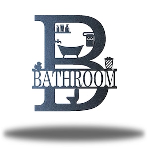 May include: A dark blue metal sign in the shape of the letter "B" with the word "BATHROOM" cut out. The letter contains bathroom-themed cutouts, including a bathtub, a toilet, and a shelf with toiletries. A rubber ducky is also included.