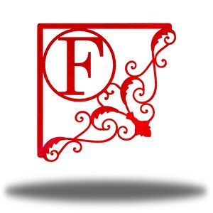 May include: Red metal monogram featuring the letter "F" in a circle with a decorative scroll design.