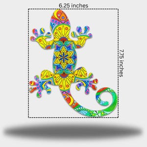 May include: A decorative lizard with a detailed, patterned design. The lizard is approximately 16 cm wide and 19.7 cm long. The design features yellow, blue, green, and red colors. The lizard's tail is curled.