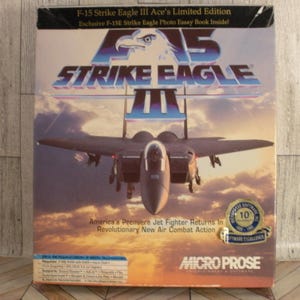 May include: F-15 Strike Eagle III Ace's Limited Edition video game box. The box features an image of an F-15 fighter jet in flight, with the game's title in large, bold letters. The box also includes the Micro Prose logo and a 10-year software excellence seal.