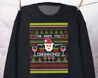 May include: Black Christmas sweater with a pixelated Santa Claus and the text "He sees you when you're drinking!"